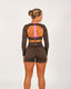 Person wearing a brown athletic outfit with pink accents on a white background