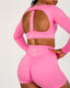 Person wearing a pink athletic outfit with mesh panels on a light gray background