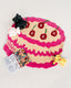 Pink and beige cake-shaped mat with plush toys and a coloring book on a white background